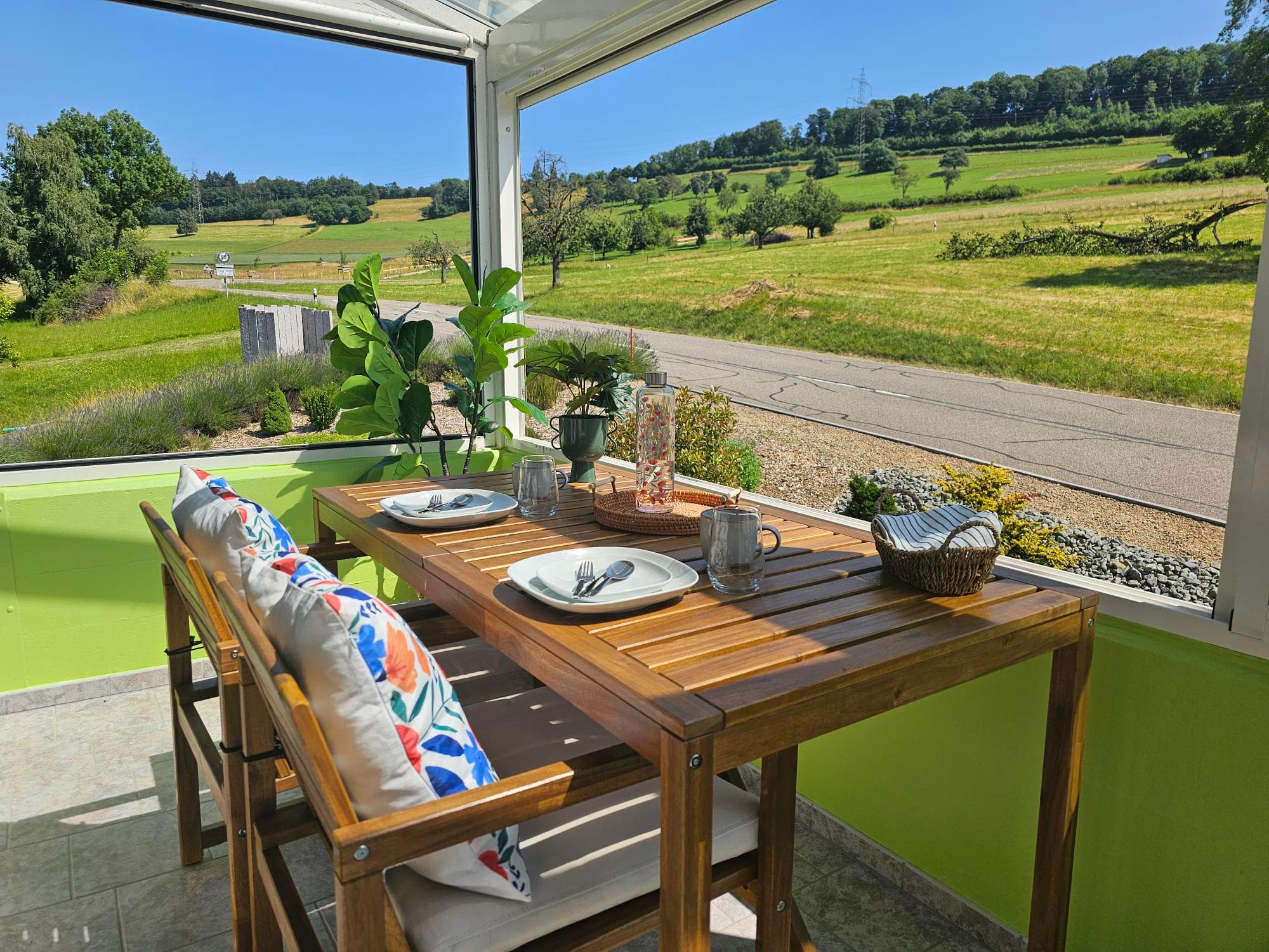 Panorama conservatory with a set table and view over the vineyards